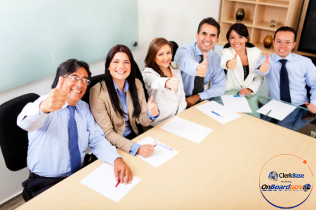 A diverse group of people in business clothing, sitting around a conference table.