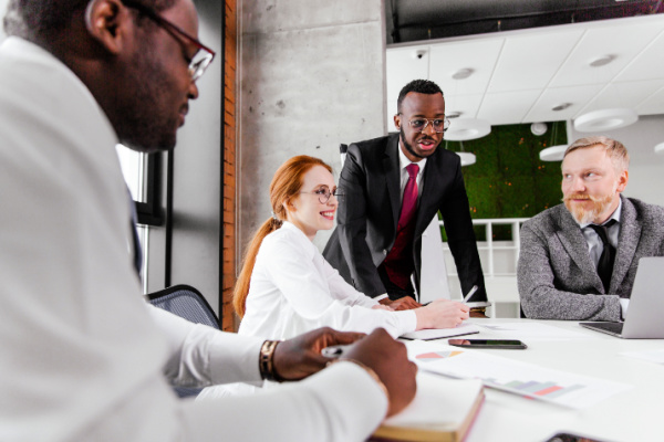 A group of people meet around a conference table.